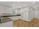 Well-lit kitchen featuring white cabinetry, granite counters, and modern appliances at 907 Tidewater Dr., North Myrtle Beach, SC 29582