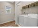 Functional laundry room with a white washer and dryer, shelving, and a window providing natural light at 907 Tidewater Dr., North Myrtle Beach, SC 29582
