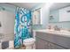 Updated bathroom vanity, toilet, storage, tub and shower with beach themed curtain and tile flooring at 9400 Shore Dr. # 716, Myrtle Beach, SC 29572
