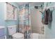 Shower and toilet in bathroom with beach themed curtain, storage, and tile flooring for easy cleaning at 9400 Shore Dr. # 716, Myrtle Beach, SC 29572