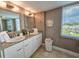 Bathroom featuring double sinks with granite counters, white cabinets and a large window at 9840 Queensway Blvd. # 331, Myrtle Beach, SC 29572