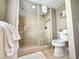 Bathroom features a tiled shower with glass door, neutral walls, updated commode, and decorative mirror at 9840 Queensway Blvd. # 331, Myrtle Beach, SC 29572