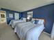 Spacious bedroom with two beds, blue accent wall, and artwork at 9840 Queensway Blvd. # 331, Myrtle Beach, SC 29572