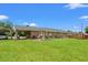 The backyard features a brick home with a grassy area, shed, and covered area for outdoor entertaining at 1005 S Main St., Mullins, SC 29574