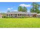 Charming single-story brick home with a well-manicured lawn and beautiful landscaping in the front yard at 1005 S Main St., Mullins, SC 29574
