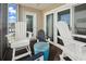 Comfortable porch with white Adirondack chairs and a small blue side table at 1011 S Ocean Blvd. # 301, North Myrtle Beach, SC 29582