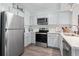 Well-equipped kitchen with stainless steel appliances, white cabinets, and hardwood floors at 1011 S Ocean Blvd. # 301, North Myrtle Beach, SC 29582