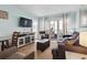 Open living room with a comfortable sofa, TV, balcony, and coastal decor at 1011 S Ocean Blvd. # 301, North Myrtle Beach, SC 29582