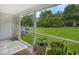 A screened back porch with plants has views of the large lawn at 1025 Penny Ln. # 1025, Myrtle Beach, SC 29577