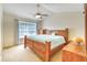 Bright main bedroom with a ceiling fan, large window, and comfortable wooden furnishings at 1025 Penny Ln. # 1025, Myrtle Beach, SC 29577