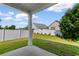 View of the outdoor patio with white fence surrounding the green lawn and other homes in the neighborhood at 1128 Sennema Circle, Myrtle Beach, SC 29588