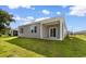 The backyard has a covered patio and sliding glass door with nice green grass and an adjacent home at 1128 Sennema Circle, Myrtle Beach, SC 29588