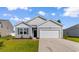 Well-manicured gray home featuring an attached garage, and beautiful landscaping at 1128 Sennema Circle, Myrtle Beach, SC 29588