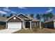 Charming brown house featuring a white garage door, complemented by well-maintained landscaping at 1239 Maxwell Dr., Little River, SC 29566