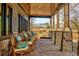 Inviting covered porch with rocking chairs, stone columns and a beautiful view of the natural surroundings at 1239 Maxwell Dr., Little River, SC 29566