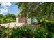 Attached garage showcasing a brown door, gravel driveway, and partial view of the charming green-painted home exterior at 127 Brown Pelican Loop, Pawleys Island, SC 29585