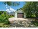 A detached garage features a brown door and light green siding, providing secure parking or storage at 127 Brown Pelican Loop, Pawleys Island, SC 29585