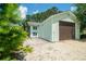 Side view of a detached garage with a concrete pad and a brown garage door, with light green siding at 127 Brown Pelican Loop, Pawleys Island, SC 29585