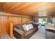 Comfortable living room with wood paneling and a cozy bed, perfect for relaxation at 127 Brown Pelican Loop, Pawleys Island, SC 29585