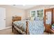 Bedroom featuring carpet, windows, and a wooden bed frame with a colorful floral bedspread at 12721 Pleasant Hill Dr., Hemingway, SC 29554