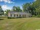 Exterior view of a single-story brick home with a well-manicured lawn and mature trees at 12721 Pleasant Hill Dr., Hemingway, SC 29554