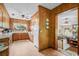 Bright kitchen with classic wood paneling, a window above the sink, and a view to the living room at 12721 Pleasant Hill Dr., Hemingway, SC 29554