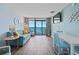 Living room with aqua colored walls, hardwood floors, aqua sofa, and ocean view balcony at 1501 S Ocean Blvd. # 1039, Myrtle Beach, SC 29577