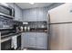 Galley kitchen featuring gray cabinets, stainless steel appliances and mosaic backsplash at 1501 S Ocean Blvd. # 1548, Myrtle Beach, SC 29577