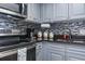 Galley kitchen featuring gray cabinets, stainless steel appliances, mosaic backsplash and granite countertops at 1501 S Ocean Blvd. # 1548, Myrtle Beach, SC 29577