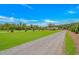 Long gravel driveway leading to a well-maintained house with a spacious lawn at 15810 County Line Rd., Andrews, SC 29510