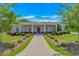 Charming exterior showcasing a well-manicured lawn, lush landscaping, and inviting walkway leading to the front door at 15810 County Line Rd., Andrews, SC 29510