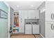 A bright laundry room featuring a washer, dryer, storage cabinets, and neutral decor at 15810 County Line Rd., Andrews, SC 29510