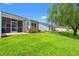 Landscaped backyard featuring lush lawn, mature trees, and a screened porch, perfect for outdoor relaxation at 1590 Palmina Loop # A, Myrtle Beach, SC 29588