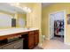 Bright bathroom with wooden vanity, large mirror, and doorway to walk-in closet with ample storage at 1590 Palmina Loop # A, Myrtle Beach, SC 29588