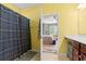 Sunny bathroom with patterned shower curtain and open doorway leading into the main bedroom at 1590 Palmina Loop # A, Myrtle Beach, SC 29588