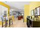 Open-concept dining area with bright yellow walls, modern decor, and hardwood floors at 1590 Palmina Loop # A, Myrtle Beach, SC 29588