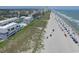 An aerial view captures the gray condominiums, a pool, the beach, and many people at 1820 N Ocean Blvd. # 303D, North Myrtle Beach, SC 29582