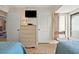 Bright bedroom showcasing two twin beds, woven dresser, and natural light from a nearby window at 1820 N Ocean Blvd. # 303D, North Myrtle Beach, SC 29582
