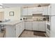 Well-lit kitchen featuring white cabinetry, appliances and a breakfast bar with seating for casual dining at 1820 N Ocean Blvd. # 303D, North Myrtle Beach, SC 29582