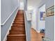 Traditional wood staircase with white railing in a home with light blue walls and wood flooring at 1857 Culbertson Ave. # 1857, Myrtle Beach, SC 29577