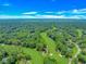 High angle view of a lush green golf course with pond and sand traps set in a neighborhood with mature trees at 189 Aspen Loop, Pawleys Island, SC 29585