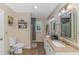 Well-lit bathroom featuring double sinks, wood flooring, and a shower with tiled walls at 189 Aspen Loop, Pawleys Island, SC 29585