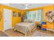 Bedroom with yellow walls, ceiling fan, a window that provides natural light, and wood-look floors at 189 Aspen Loop, Pawleys Island, SC 29585
