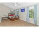 This bright bedroom has a ceiling fan, laminate floors, two windows, and a red accent pillow at 189 Aspen Loop, Pawleys Island, SC 29585
