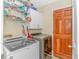 Well-equipped laundry room with modern washer and dryer, ample storage, and natural wood door at 189 Aspen Loop, Pawleys Island, SC 29585