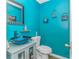 Stylish powder room with bold turquoise walls, modern fixtures, and unique decorative touches at 189 Aspen Loop, Pawleys Island, SC 29585