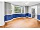 Hardwood floors, ceiling fan, large windows, and blue accent wall in this open dining room at 203 Lakeland Dr., Conway, SC 29526