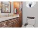 Bathroom vanity area with granite countertop, dark cabinets, and a decorative window at 208 Millwood Dr., Surfside Beach, SC 29575