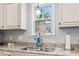 A kitchen sink with granite countertop and window view adds charm and functionality to the cooking space at 208 Millwood Dr., Surfside Beach, SC 29575