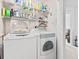 Bright laundry room with a stacked washer and dryer, white wire shelves, and white walls at 208 Millwood Dr., Surfside Beach, SC 29575